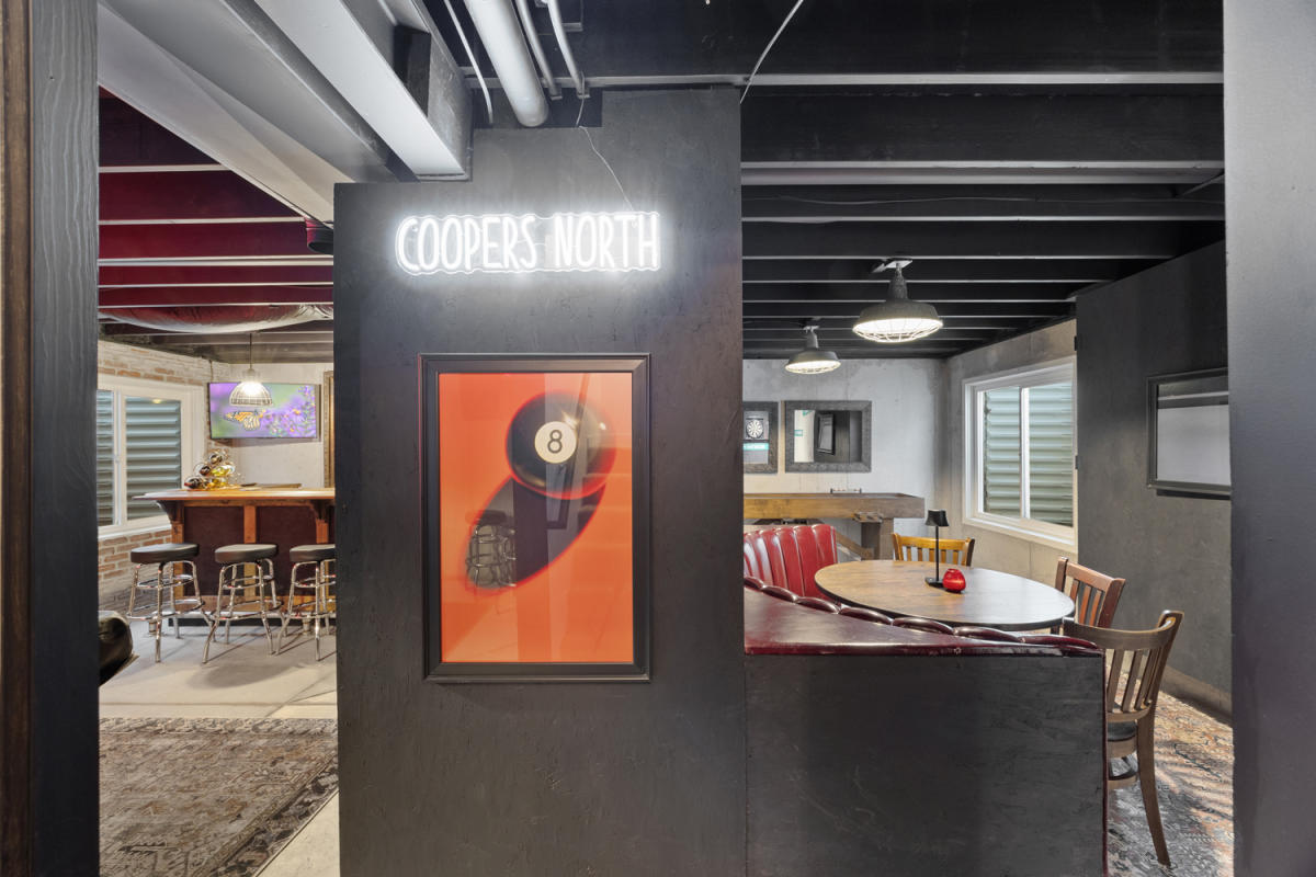 a hangout area with a neon sign and themed pool hall decoration