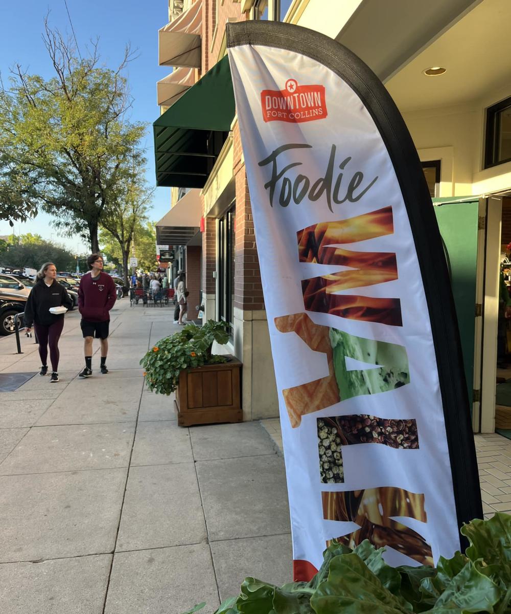 People walk down a street in Fort Collins attending the Foodie Walk